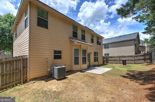 back of property with central AC unit and a patio