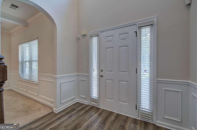 entrance foyer with crown molding, a healthy amount of sunlight, and dark hardwood / wood-style floors