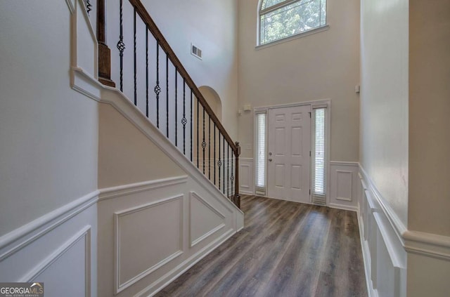 entrance foyer with a towering ceiling and dark hardwood / wood-style floors