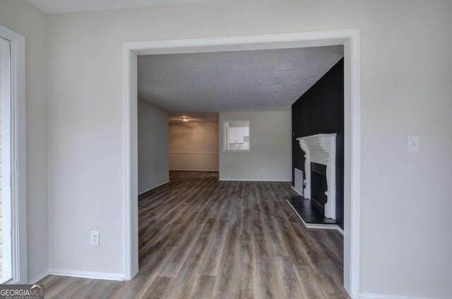 unfurnished living room featuring dark hardwood / wood-style floors and a textured ceiling