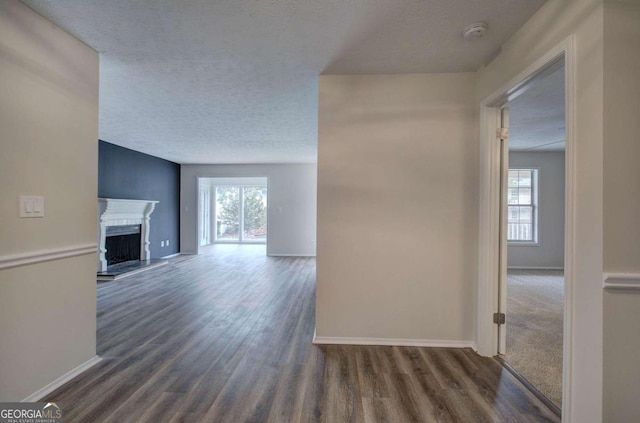 hallway with dark hardwood / wood-style floors and a textured ceiling