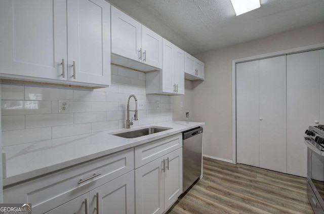 kitchen with hardwood / wood-style floors, white cabinetry, sink, and appliances with stainless steel finishes