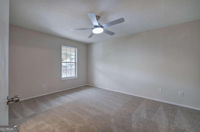 carpeted spare room with ceiling fan and a textured ceiling