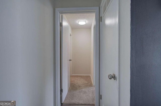 corridor featuring a textured ceiling and carpet floors