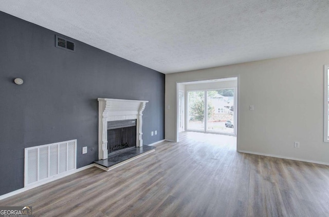 unfurnished living room featuring light hardwood / wood-style floors and a textured ceiling