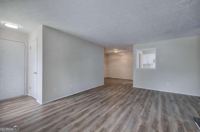 unfurnished room with dark hardwood / wood-style floors and a textured ceiling