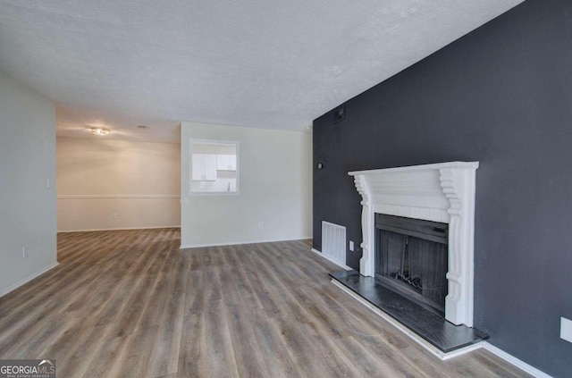 unfurnished living room featuring hardwood / wood-style floors and a textured ceiling