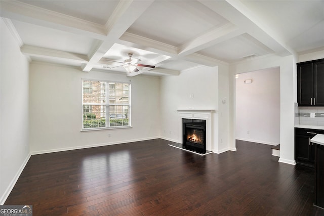 unfurnished living room with beamed ceiling, dark hardwood / wood-style flooring, ceiling fan, and ornamental molding