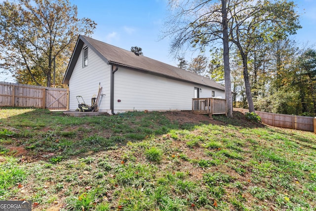 back of house with a wooden deck and a yard