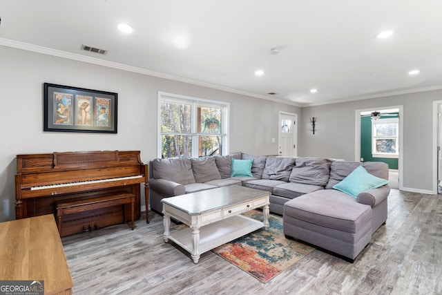 living room with crown molding, ceiling fan, and light hardwood / wood-style floors