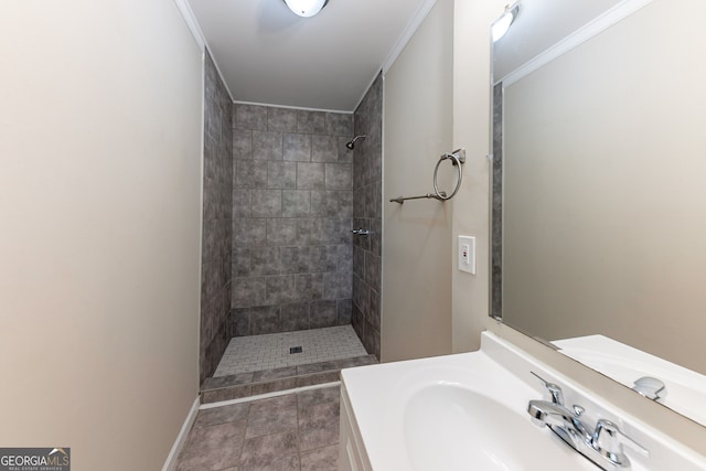 bathroom featuring ornamental molding, tile patterned flooring, vanity, and a tile shower