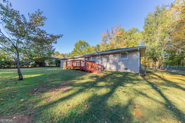 back of house featuring a wooden deck and a yard