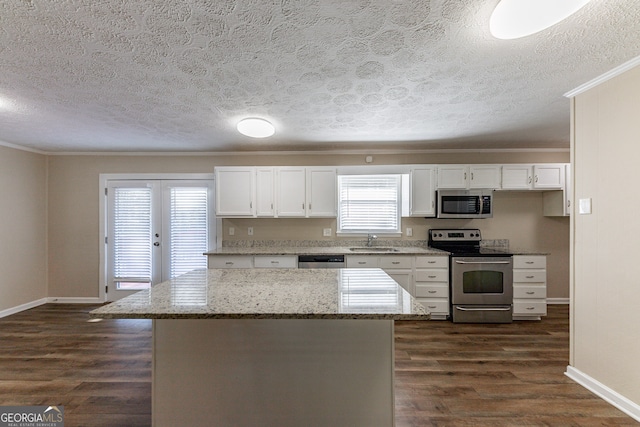 kitchen featuring white cabinets, light stone countertops, dark hardwood / wood-style floors, and appliances with stainless steel finishes