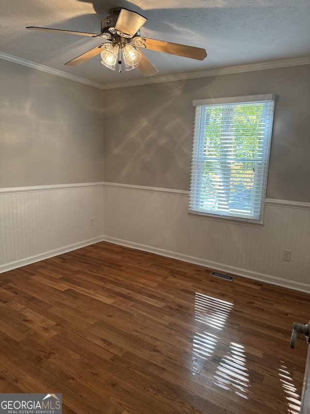 unfurnished room featuring ornamental molding, dark wood-type flooring, ceiling fan, and a textured ceiling