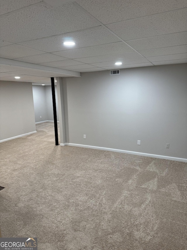 basement featuring a drop ceiling and carpet flooring