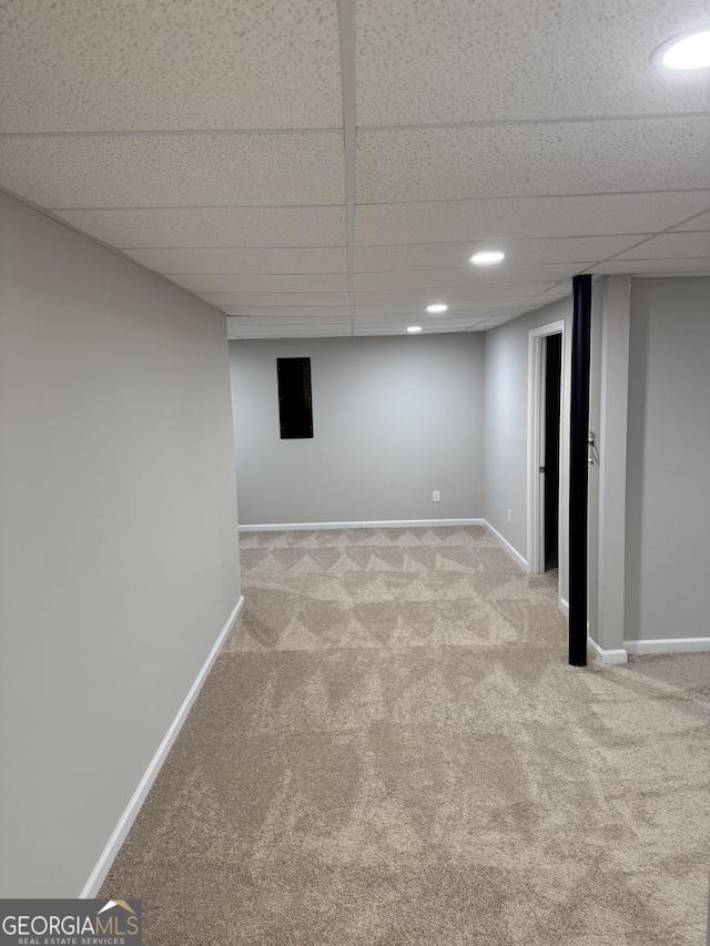 basement with light colored carpet and a drop ceiling