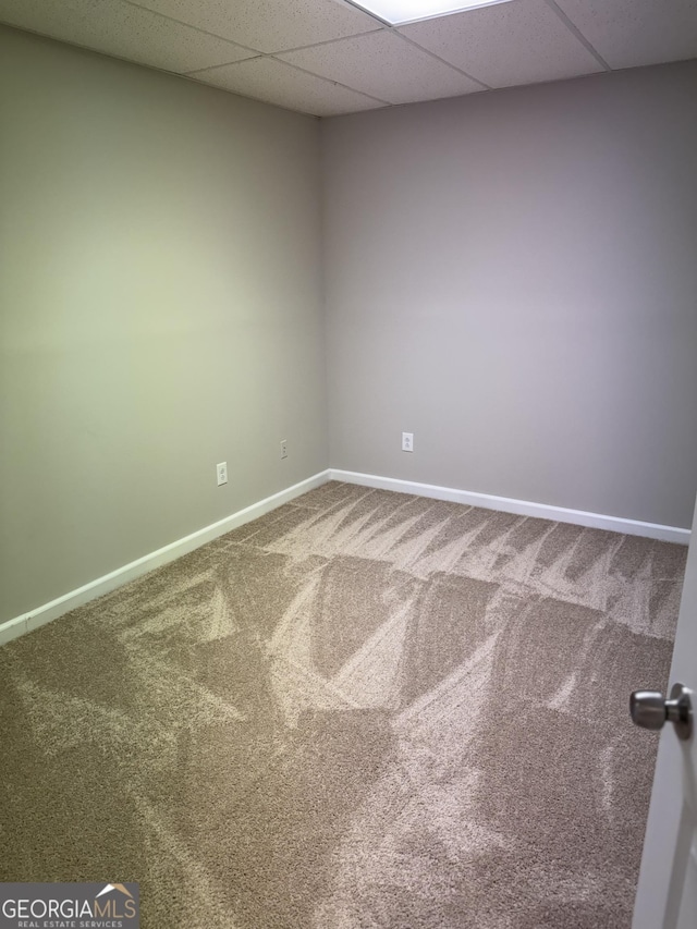 empty room featuring carpet floors and a drop ceiling