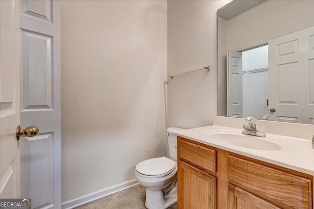 bathroom with tile patterned flooring, vanity, and toilet