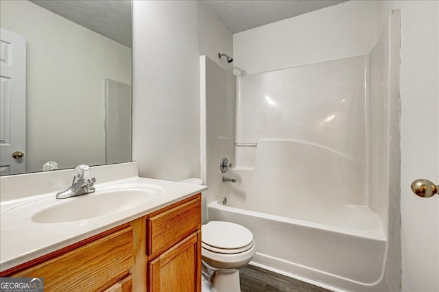 full bathroom featuring wood-type flooring, a textured ceiling, toilet, and vanity