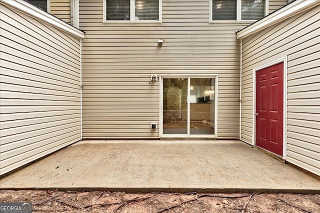 view of exterior entry with a patio area