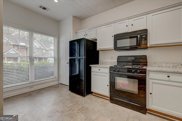 kitchen with black appliances, white cabinetry, a textured ceiling, and light stone countertops