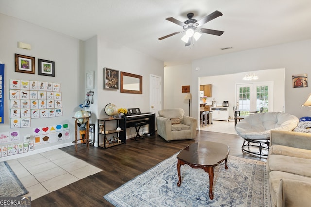 living room with french doors, ceiling fan with notable chandelier, and wood-type flooring