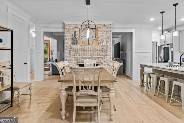 dining area featuring light hardwood / wood-style floors and ornamental molding