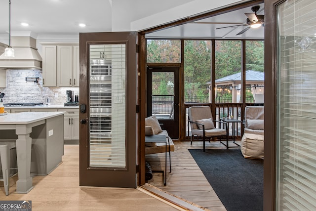 kitchen with white cabinets, decorative backsplash, light hardwood / wood-style floors, and hanging light fixtures