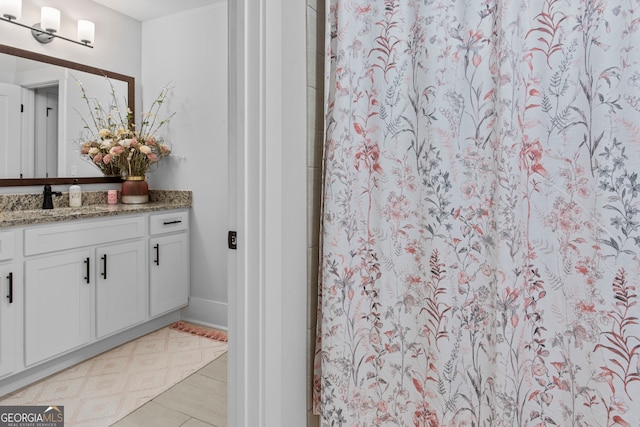 bathroom featuring tile patterned flooring, vanity, and walk in shower