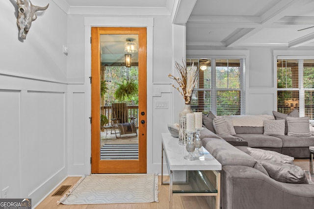 doorway to outside featuring beam ceiling, crown molding, coffered ceiling, and light wood-type flooring