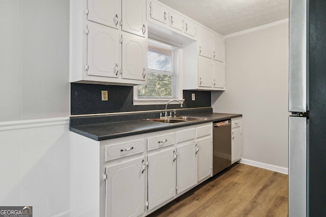 kitchen with sink, appliances with stainless steel finishes, light hardwood / wood-style flooring, crown molding, and white cabinets