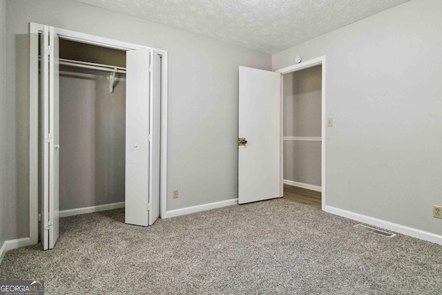 117 Neal Ave, Stockbridge, GA 30281 - unfurnished bedroom with carpet, a textured ceiling, baseboards, and a closet