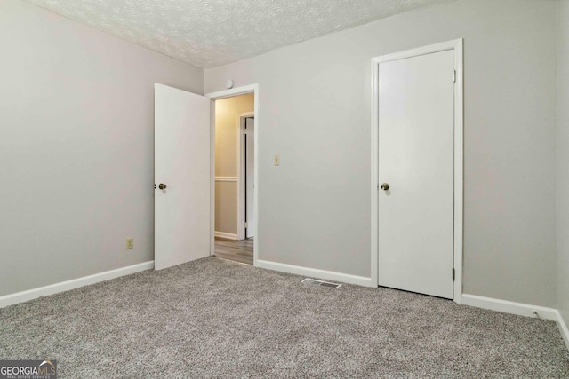 117 Neal Ave, Stockbridge, GA 30281 - unfurnished bedroom featuring carpet flooring, baseboards, and a textured ceiling