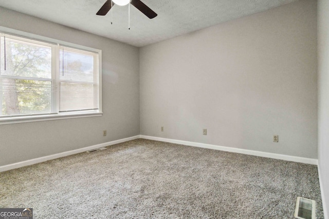 carpeted spare room with a textured ceiling and ceiling fan