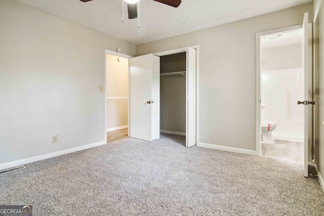 unfurnished bedroom with connected bathroom, a closet, light colored carpet, and ceiling fan