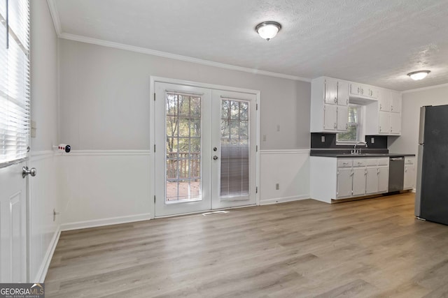 kitchen with french doors, white cabinetry, appliances with stainless steel finishes, sink, and light hardwood / wood-style flooring