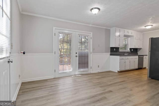 117 Neal Ave, Stockbridge, GA 30281 - kitchen with stainless steel appliances, french doors, dark countertops, crown molding, and light wood finished floors