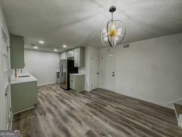 kitchen featuring stainless steel fridge, dark hardwood / wood-style flooring, a textured ceiling, and sink