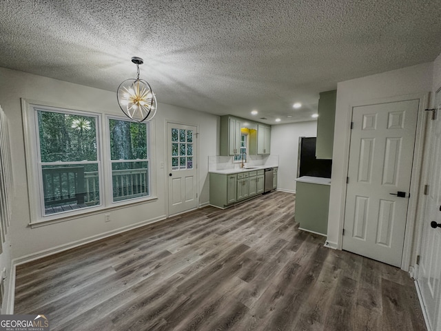 interior space with appliances with stainless steel finishes, a textured ceiling, dark wood-type flooring, sink, and decorative light fixtures