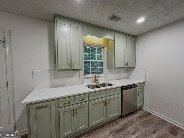 kitchen featuring sink, dark hardwood / wood-style flooring, stainless steel dishwasher, backsplash, and a textured ceiling