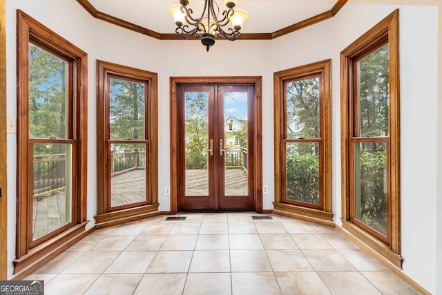 entryway featuring ornamental molding, french doors, a chandelier, and light tile patterned floors