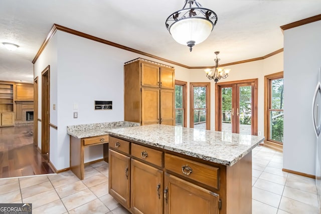 kitchen featuring crown molding, a center island, decorative light fixtures, and light tile patterned floors