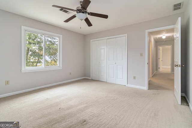 unfurnished bedroom with a closet, light carpet, and ceiling fan