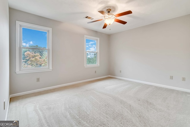 carpeted spare room with ceiling fan and a healthy amount of sunlight