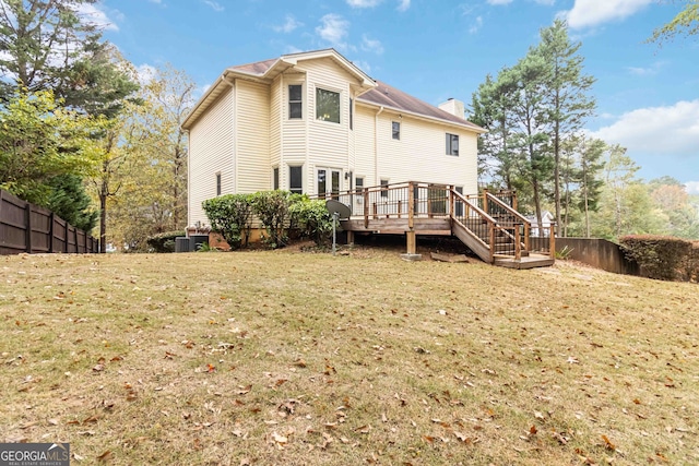 back of house featuring a wooden deck and a yard