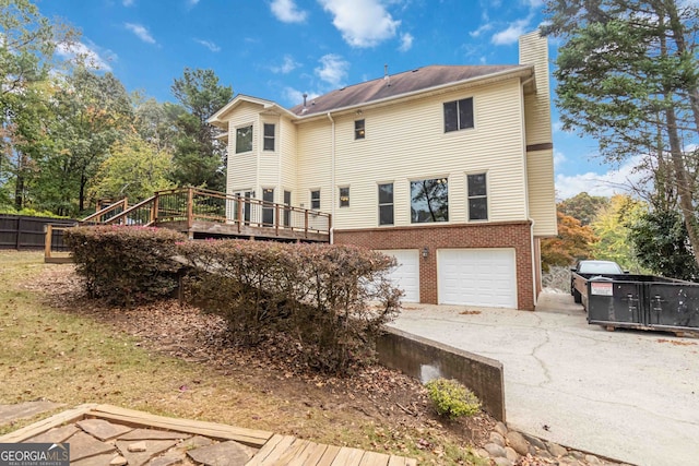 rear view of house with a deck and a garage