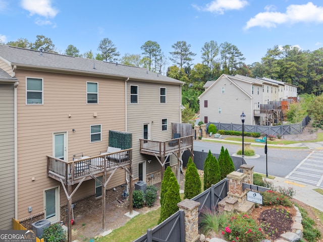 back of house with a wooden deck and a patio area