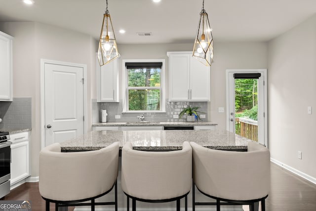 kitchen featuring white cabinets, a healthy amount of sunlight, and pendant lighting