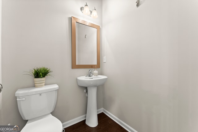 bathroom with hardwood / wood-style floors and toilet