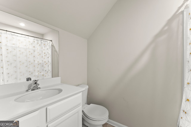 bathroom featuring vanity, vaulted ceiling, and toilet